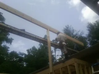 Carpenter setting a ridge beam over a new addition frame — Ice Dam Removal by Roofing Brothers in Carmichaels