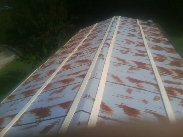 Rusted metal roof panels with new wood purlins before replacement — Storm Damage Roof Repair in Carmichaels by Roofing Brothers