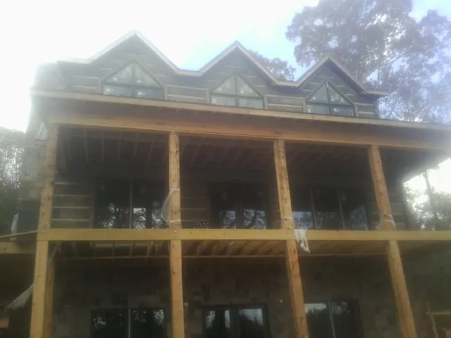 Dormers and porch framing on a large log home under construction — Roof Coating work by our crew in Carmichaels