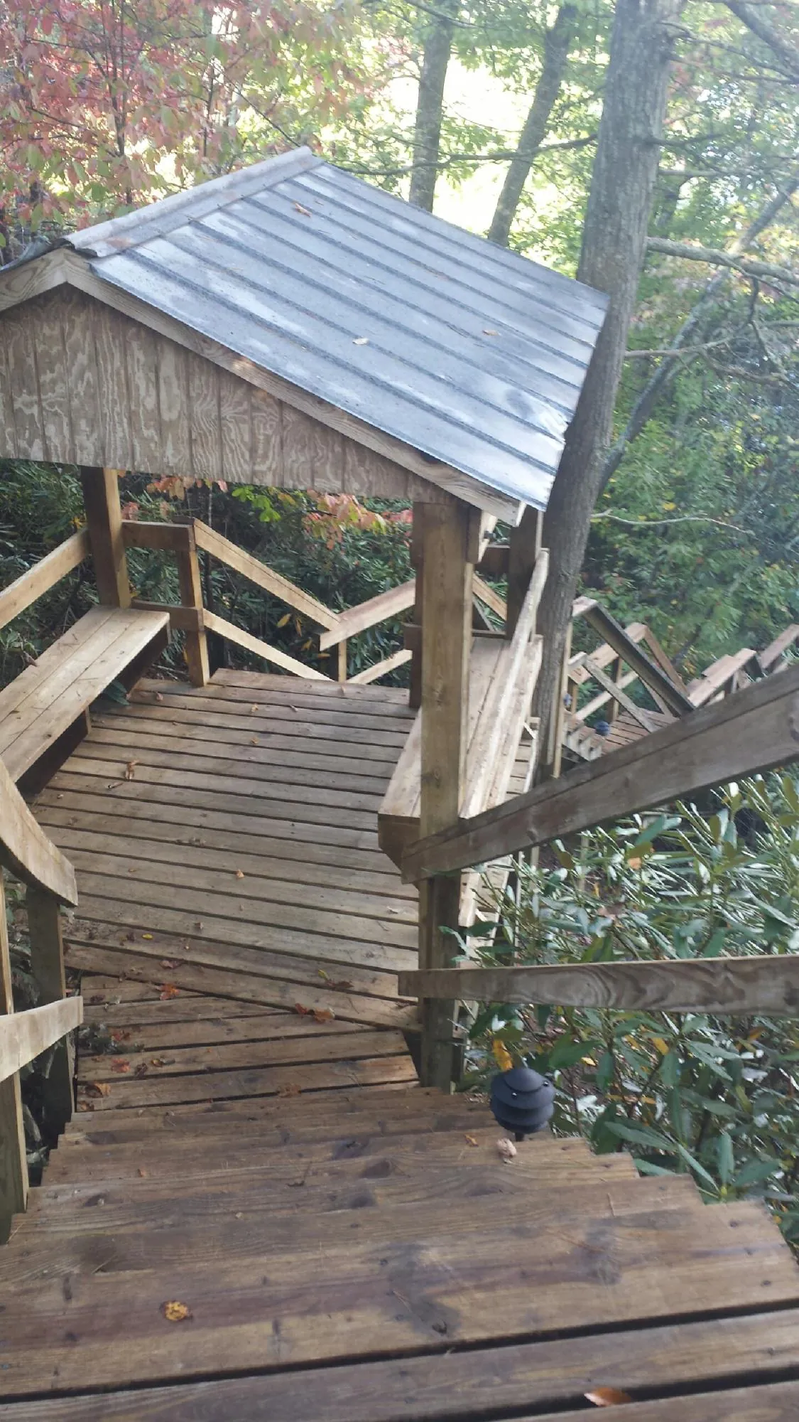 Metal roofed shelter over wooden steps on a wooded walkway — Skylight Repair & Installation work by our crew in Carmichaels