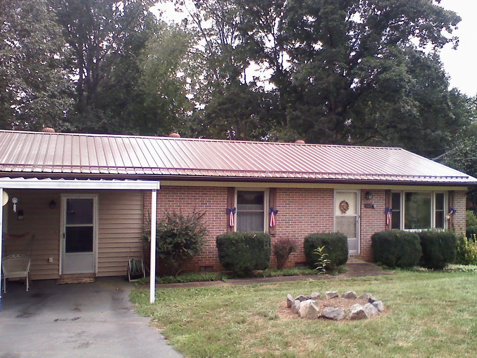 Bronze metal roof and carport on a brick ranch home — Roof Repair work by our crew in Carmichaels